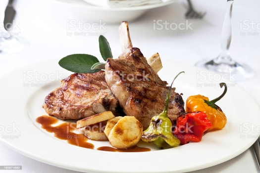 Veal chop with vegetable, sauce and sage.